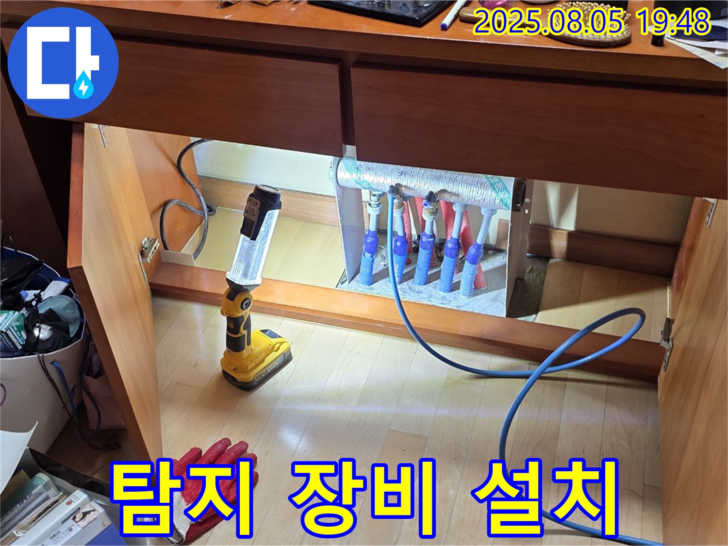양주시 삼숭동 양주자이아파트 누수 - 화장대 아래 분배기에 누수 탐지 장비를 설치하는 모습