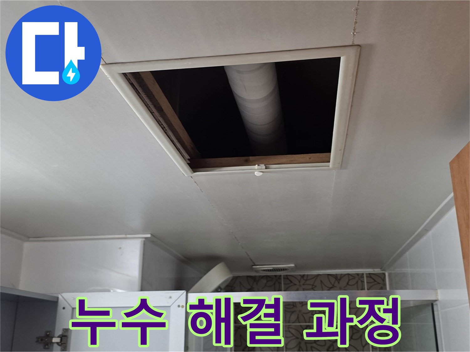 화장실 천장 마감재를 열어 내부의 하수 배관을 확인하는 장면입니다.