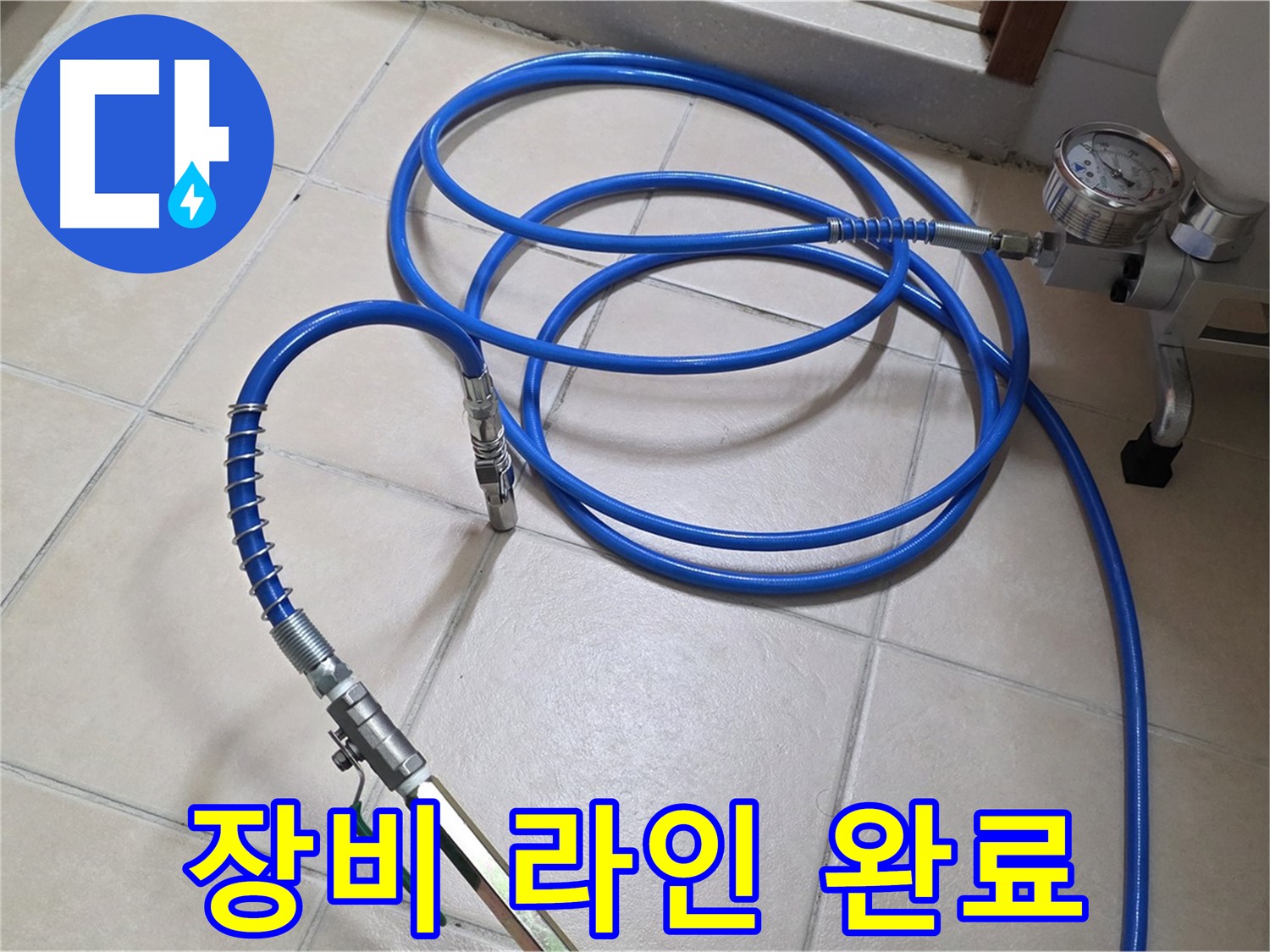 화장실 타일 바닥에 파란색 테스트용 호스가 놓여 있습니다