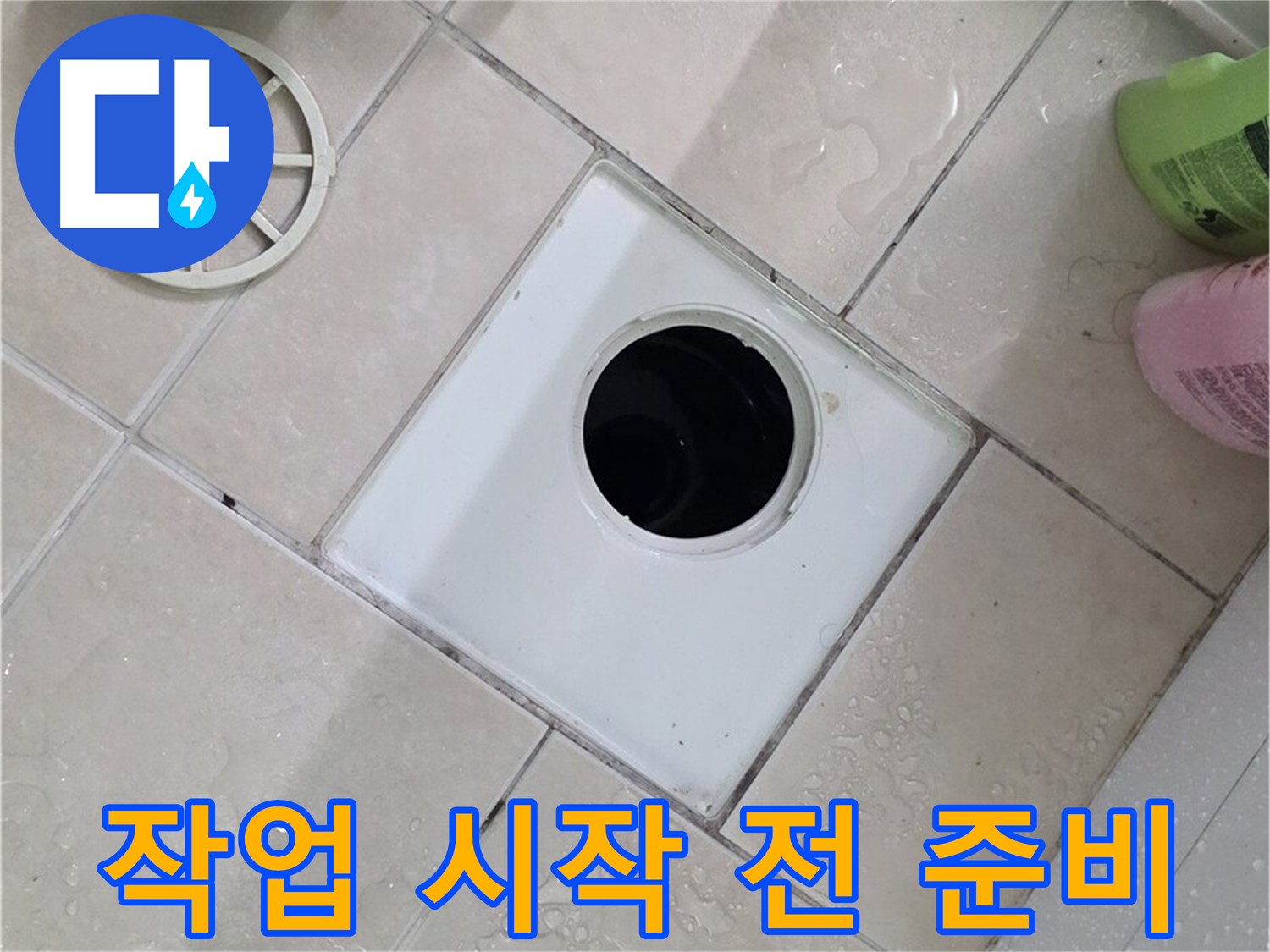 화장실 바닥 타일 위에 탈거된 배수구 부속과 유가 덮개