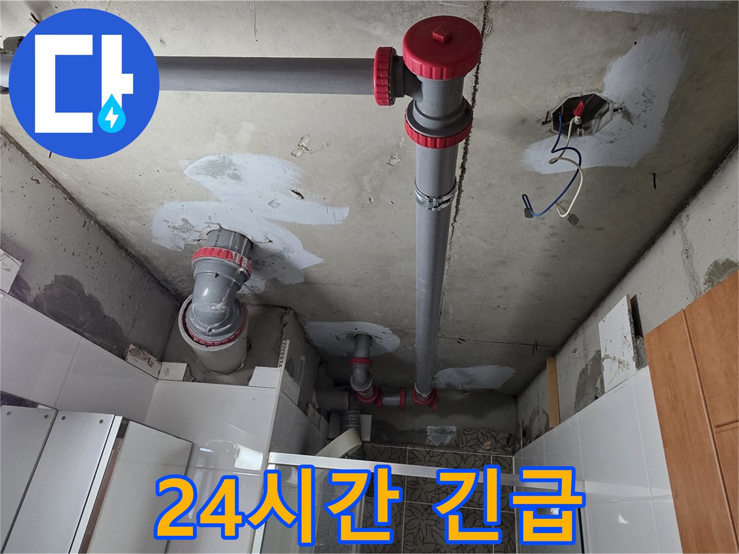 천장 콘크리트 면에 설치된 붉은색 연결 부품과 회색 PVC 파이프