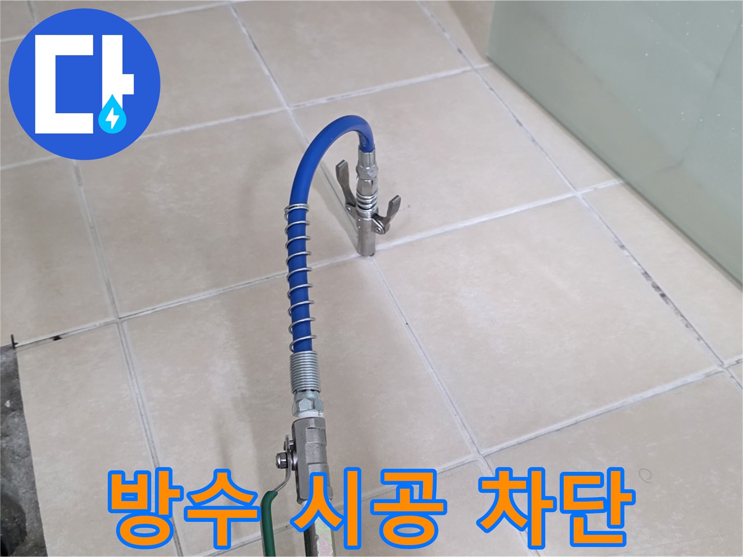화장실 타일 바닥 유가 부근에 연결된 파란색 호스 및 장비 모습