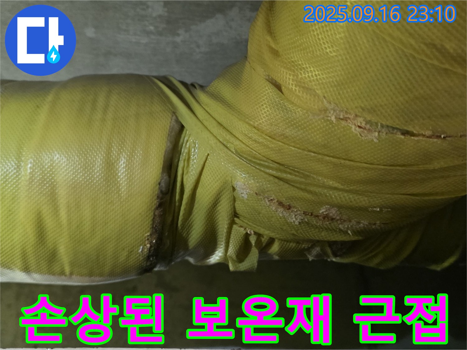 손상된 배관 보온재를 근접 촬영한 모습입니다 - 자세히 살펴보면 누수의 흔적을 찾을 수 있습니다.