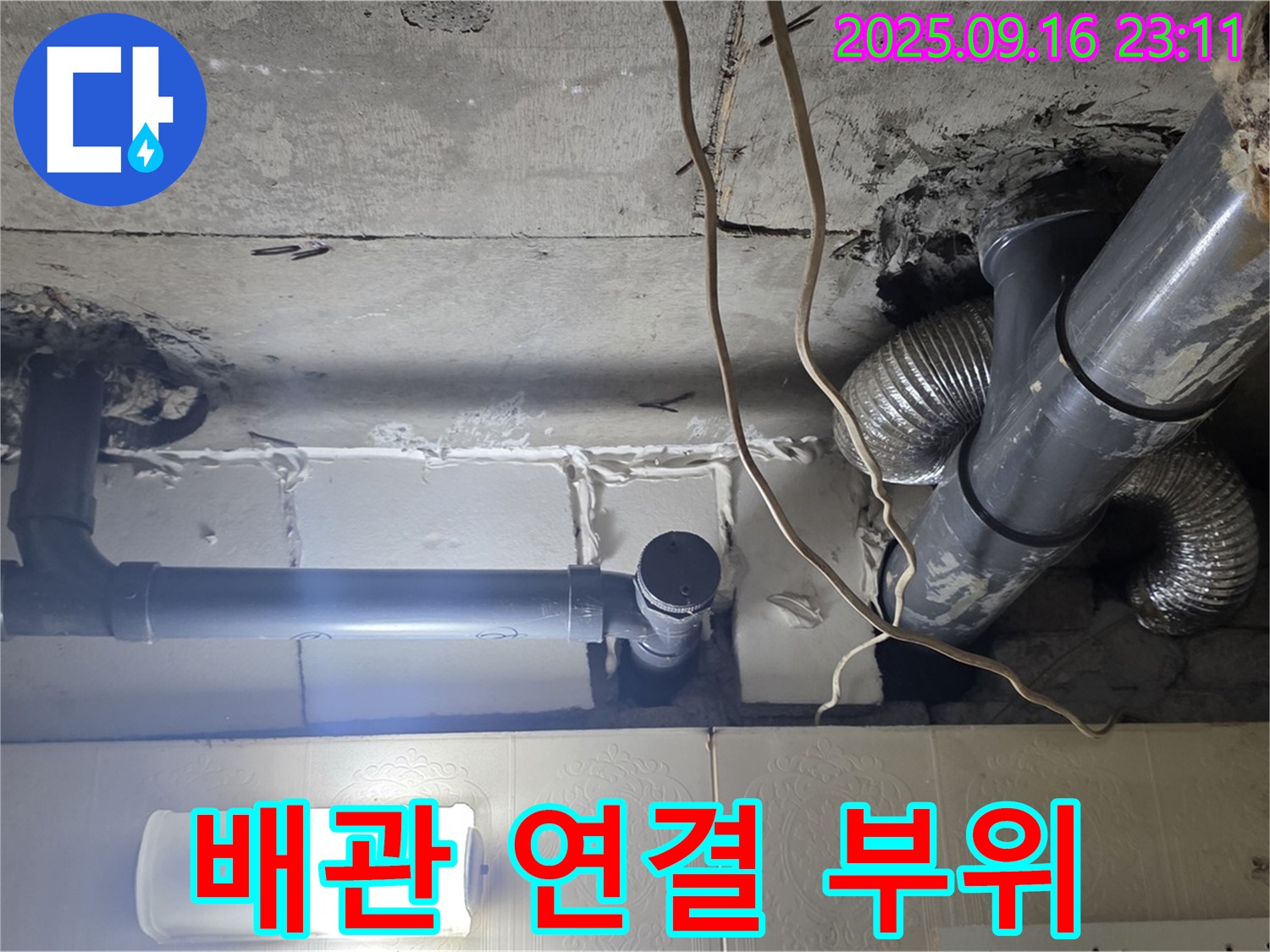천장 배관 연결 부위의 모습 - 연결 부위 주변을 자세히 살펴보고 있습니다.