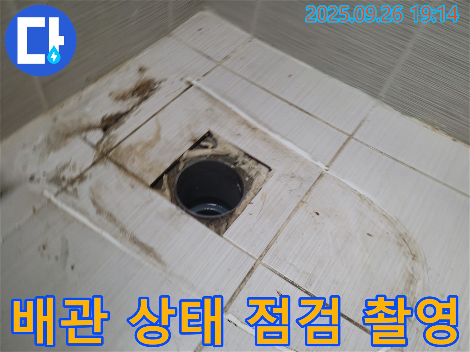 동두천시 봉암동 누수 - 배수구 주변 타일 제거 후 배관 상태를 점검하고 사진으로 기록하는 모습