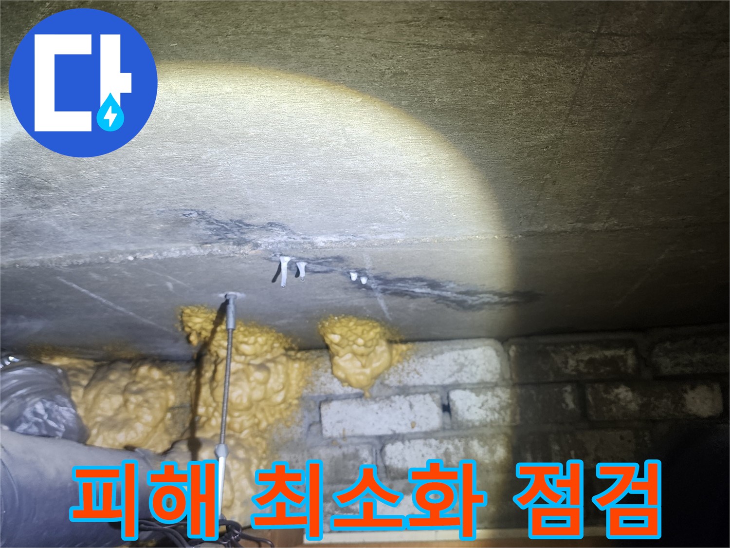 아랫집 화장실 점검구를 열어 누수 피해 상황을 확인하는 사진