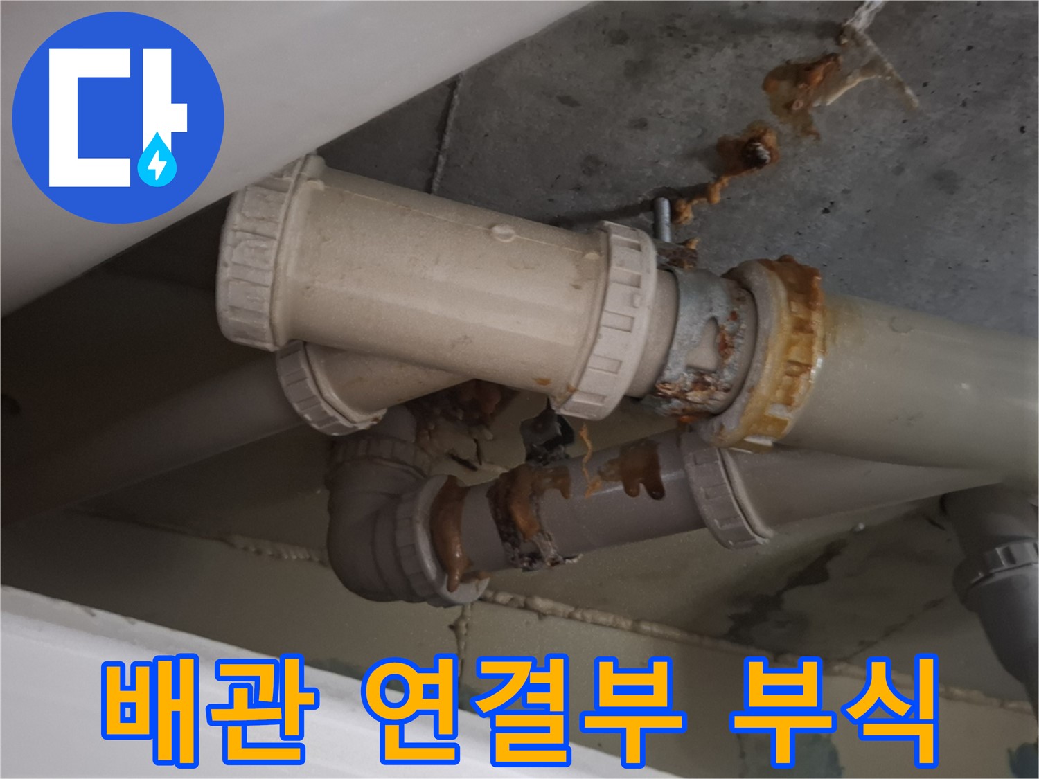 배관 연결부 부식 - 하수 배관 연결 부위가 심하게 낡아서 물이 새고 있는 모습입니다 - 낡은 연결 부위는 누수의 주요 원인입니다.