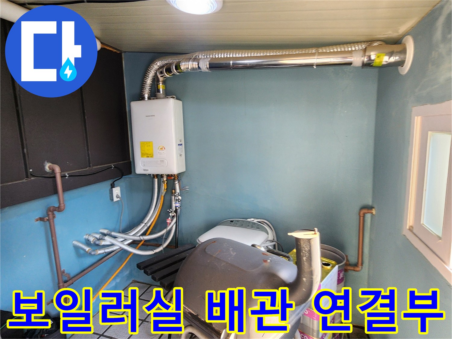 보일러 하단 배관-배관 연결 부위의 미세한 물샘 여부를 점검 중