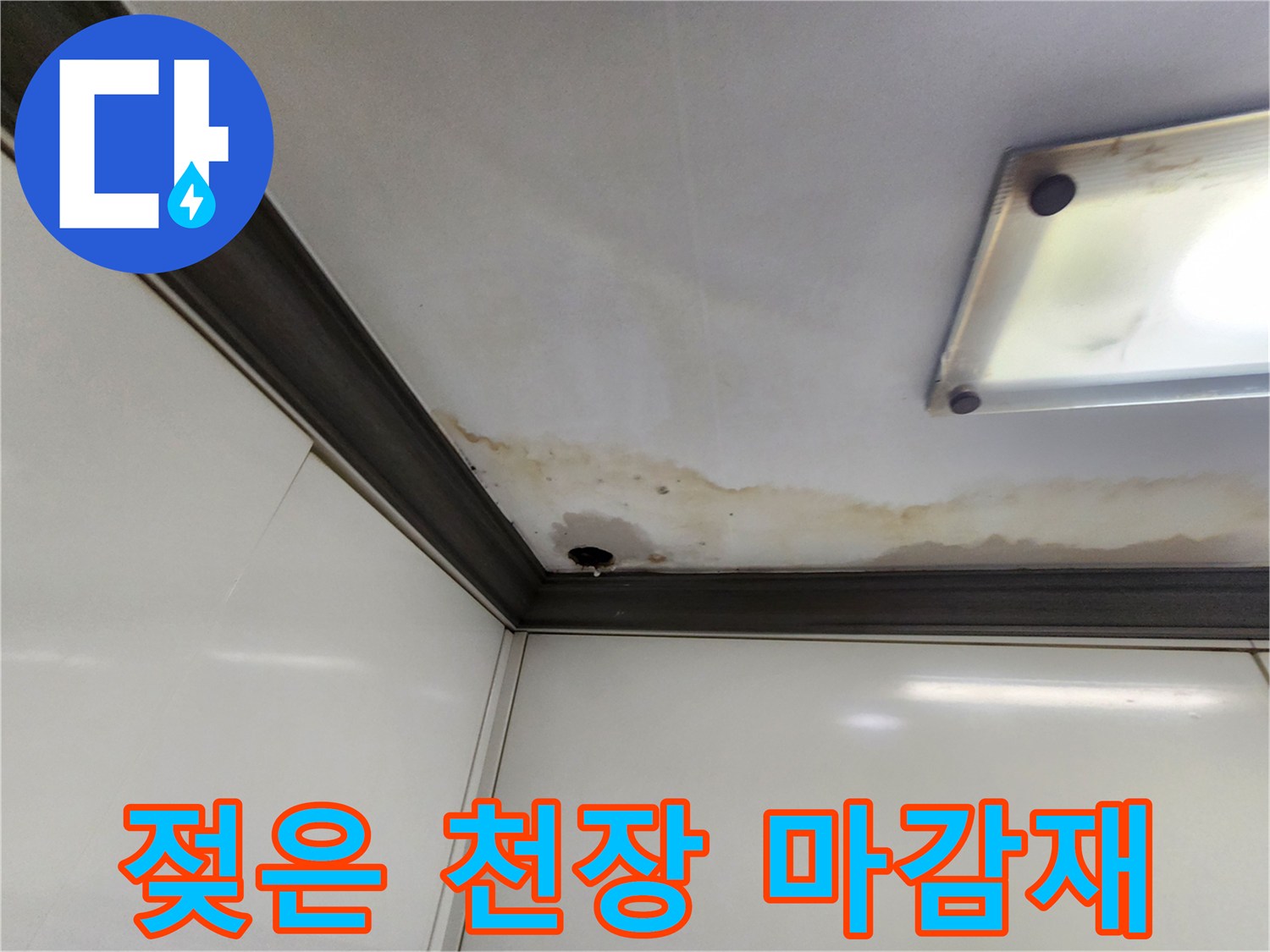 천장 조명 주변의 갈색 누수 얼룩과 변색된 면