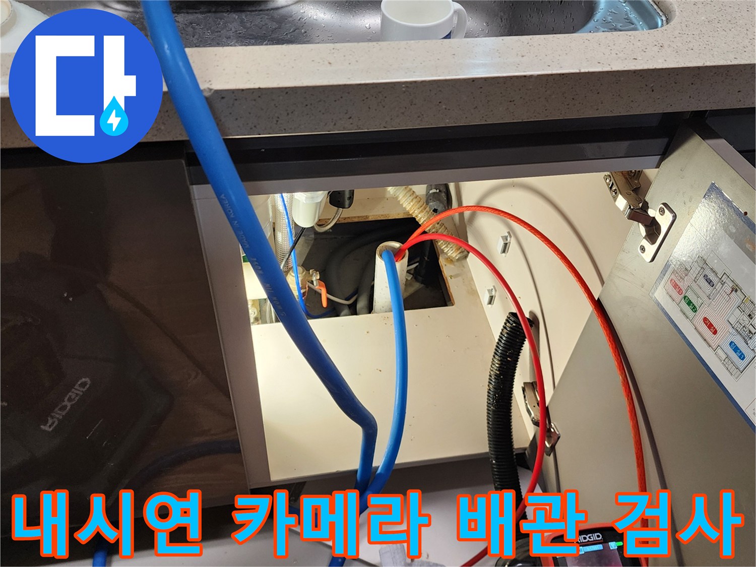 싱크대 하부장 배관 내부의 균열을 찾기 위해 내시경 카메라를 조작하는 엔지니어의 작업 현장