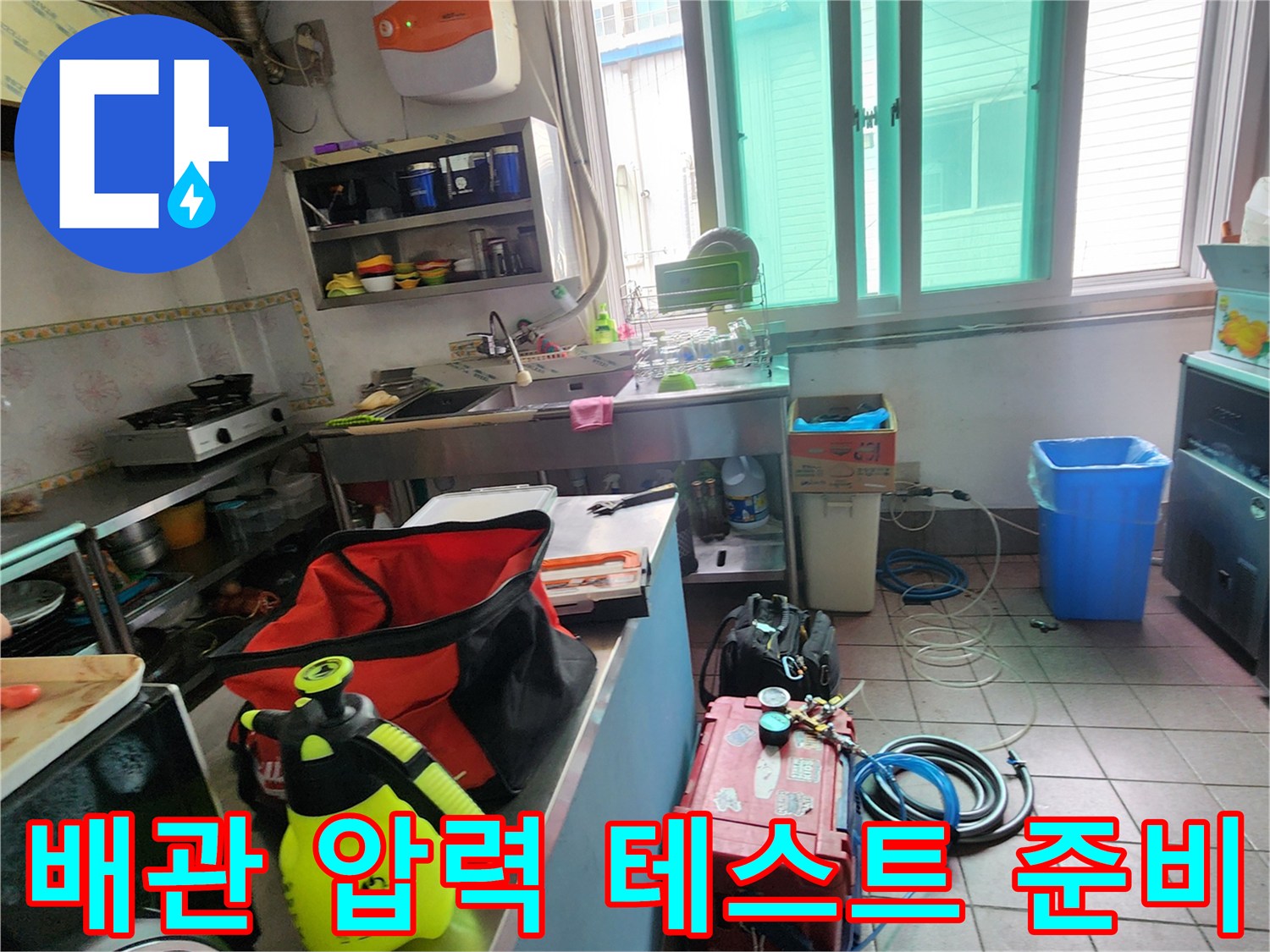 누수 지점을 찾기 위해 주방 바닥에 준비된 공압 테스트 장비 세트
