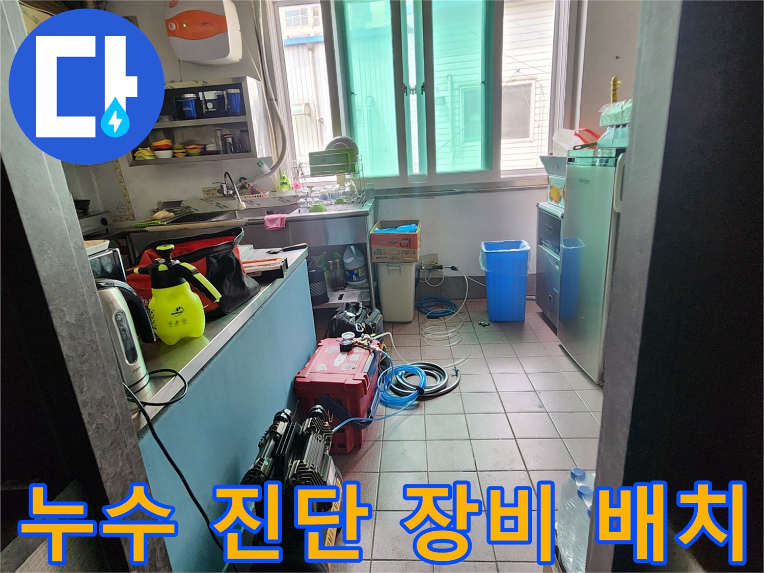 상가 주방 바닥에 놓인 검은색 콤프레샤와 압력 측정용 탱크