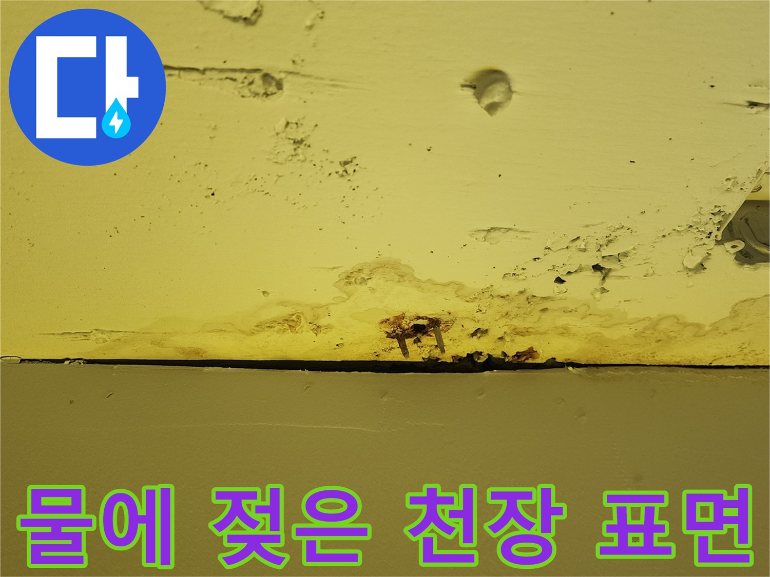 천장 마감재의 물샘 흔적과 습기로 인한 변색된 부분의 근접 사진