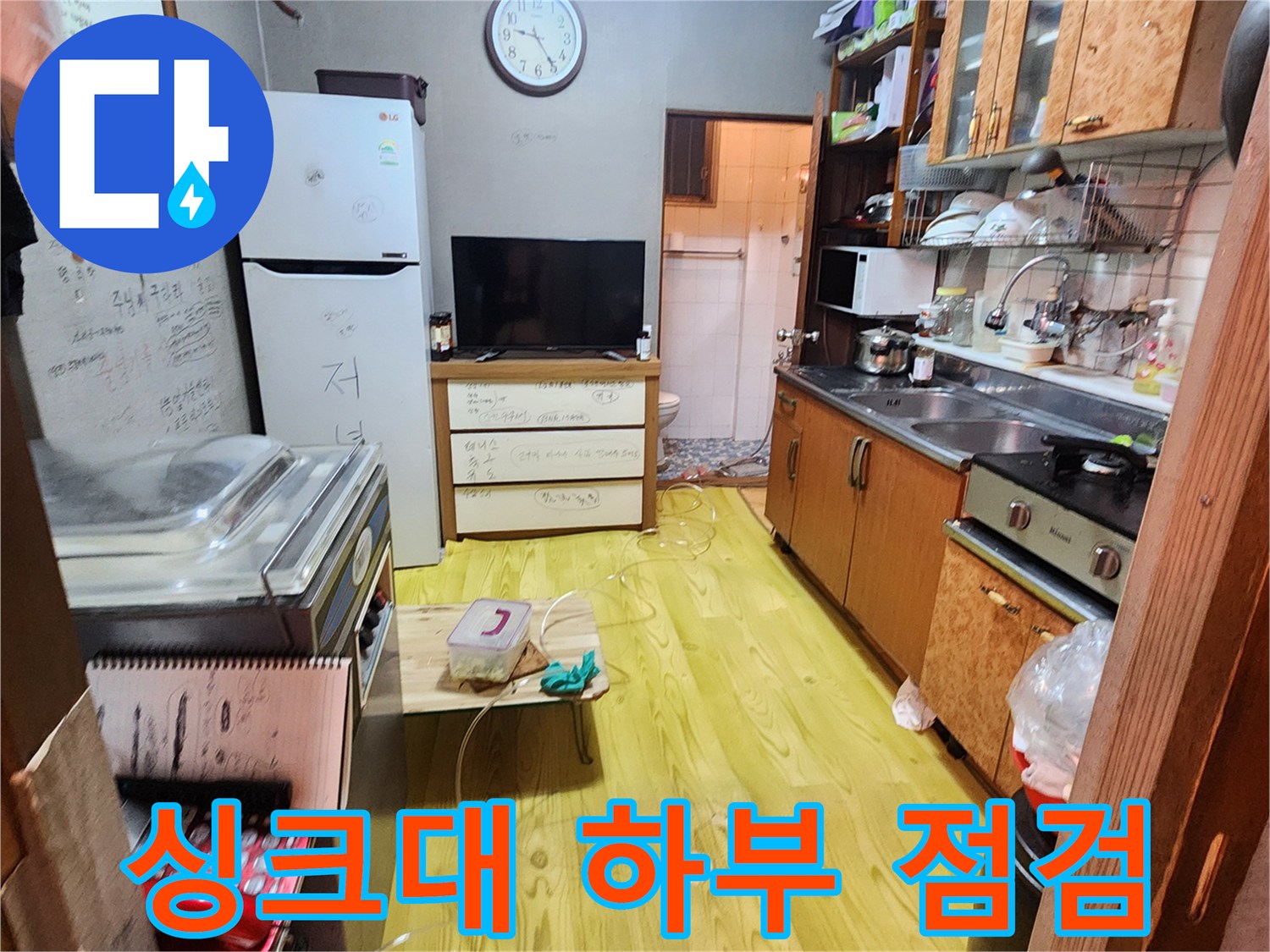 주방 싱크대 옆 공간에 누수 탐지 장비를 세팅한 현장 사진입니다.