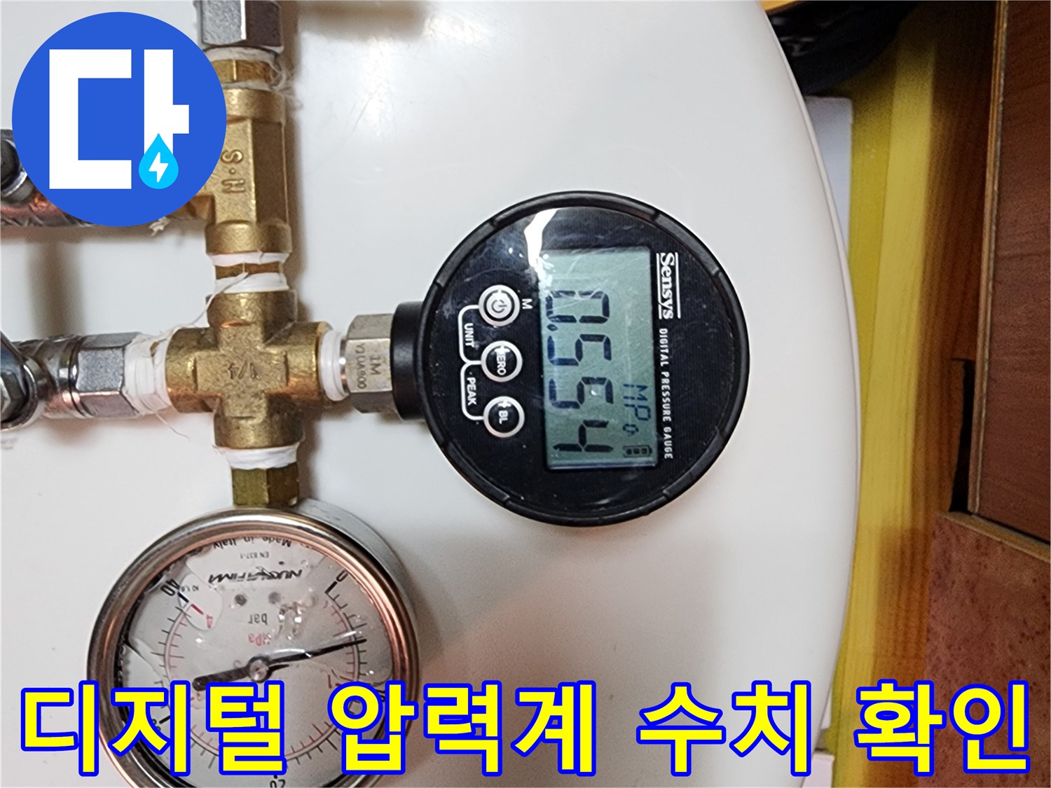 배관의 기밀 상태를 확인하기 위해 디지털 압력계로 압력을 측정하는 모습입니다.