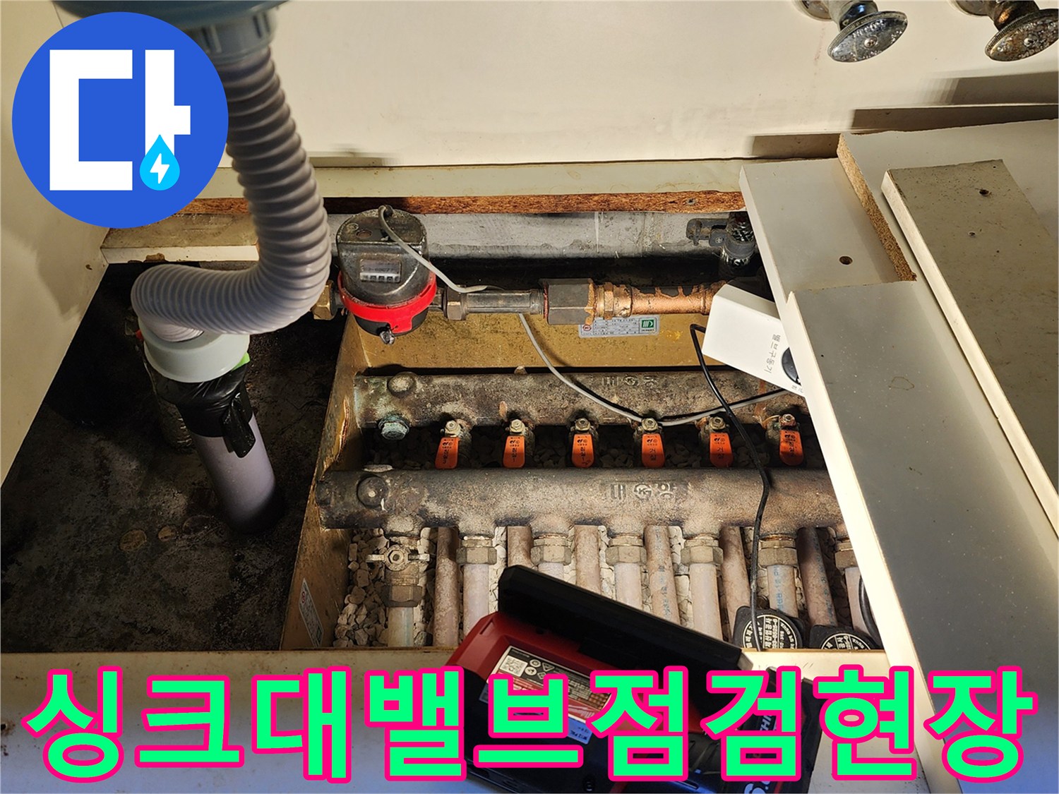 싱크대 아래 수도 밸브와 계량기가 모여있는 배관 내부 사진