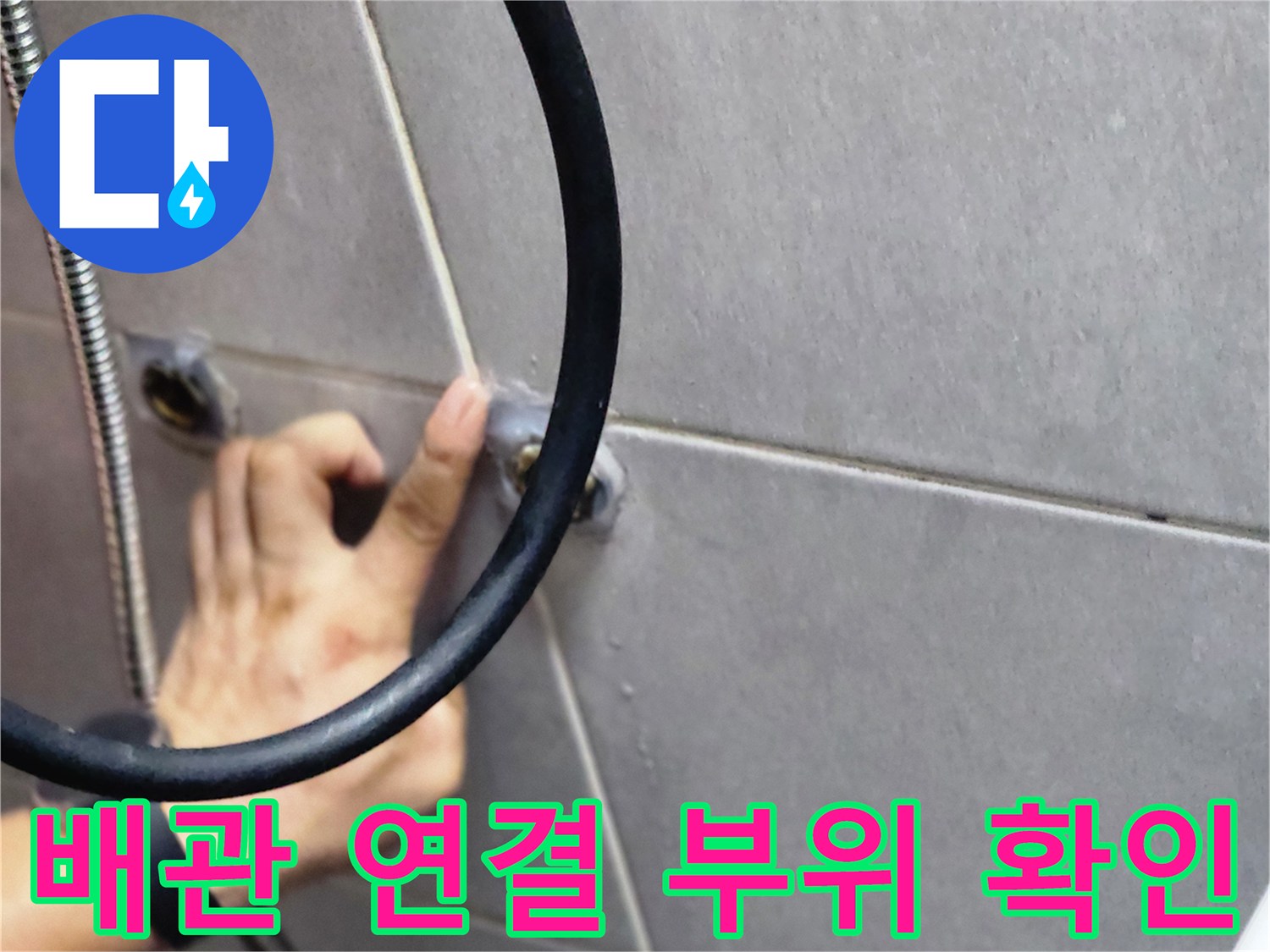 화장실 타일 벽면 배관 연결 지점을 점검하는 엔지니어의 손