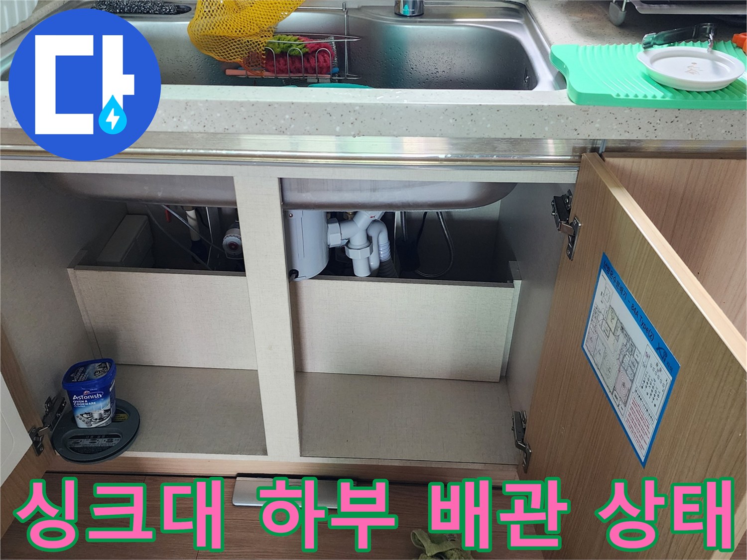 주방 싱크대 하부장 내부의 배수 배관 연결 부위 모습입니다.