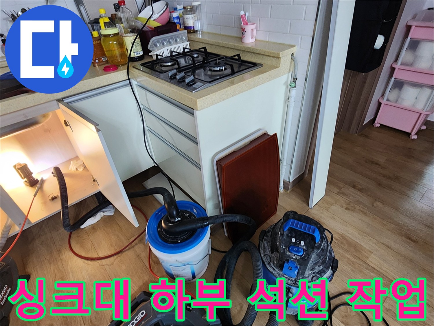 양주 옥정동 주방 싱크대 하부장 내부의 배관 청소를 위한 전문 석션 장비 배치 상태