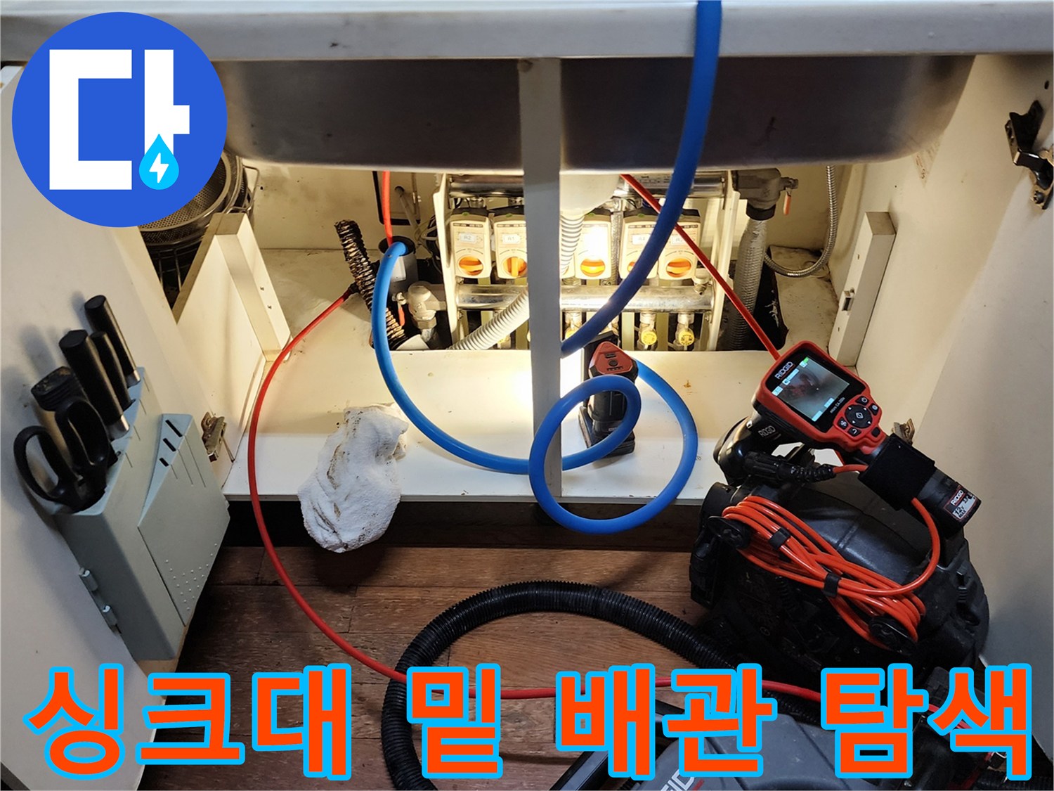 내시경 카메라 화면을 보며 싱크대 하부 배관의 누수 여부를 판단하는 엔지니어의 작업