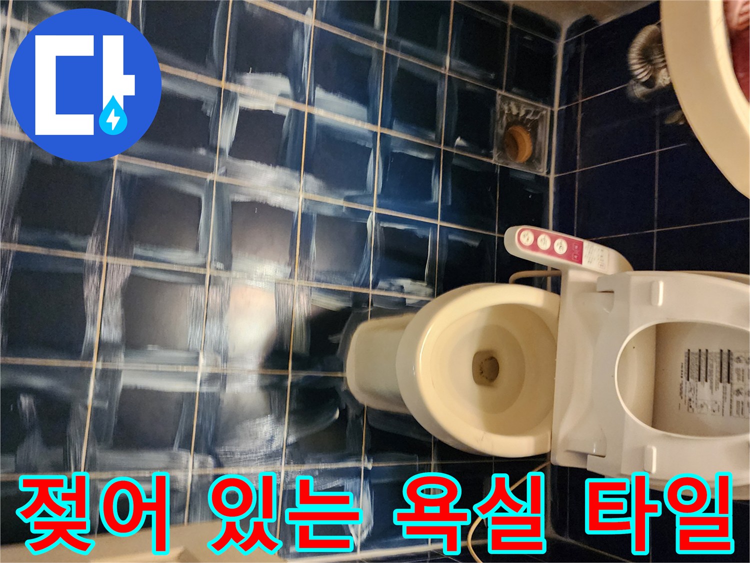물기가 남아있는 푸른색 욕실 바닥과 변기 하부 시설