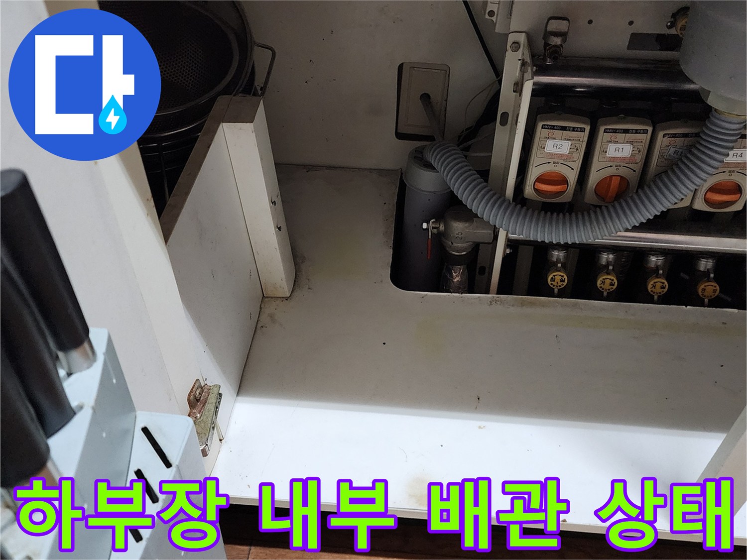 물샘 흔적이 보이는-욕실 하부장 내부의 배관 및 바닥재 모습