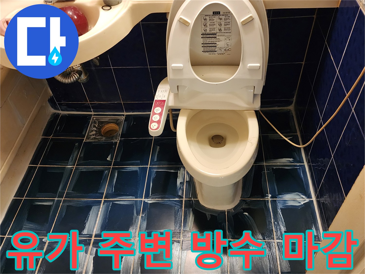 변기와 세면대 아래 푸른 타일 위로 하얀색 도포 흔적이 있습니다.