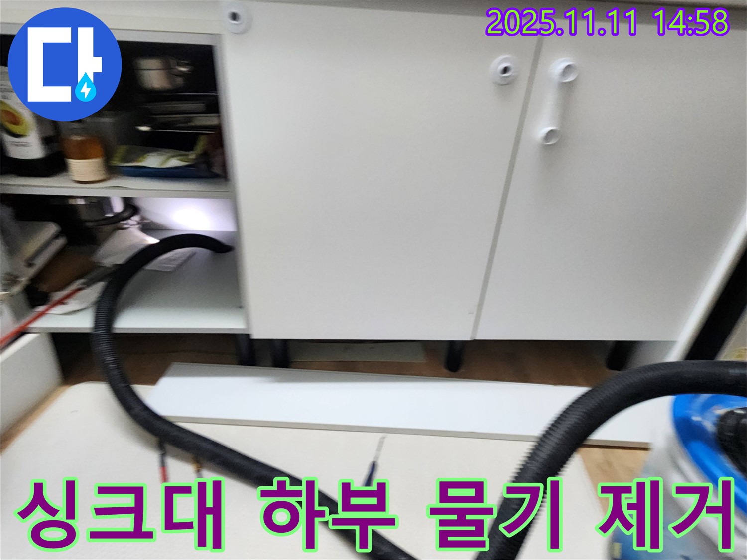 싱크대 하부 물기 제거 - 누수 후 남은 물기를 흡입기로 꼼꼼하게 제거하고 있습니다.