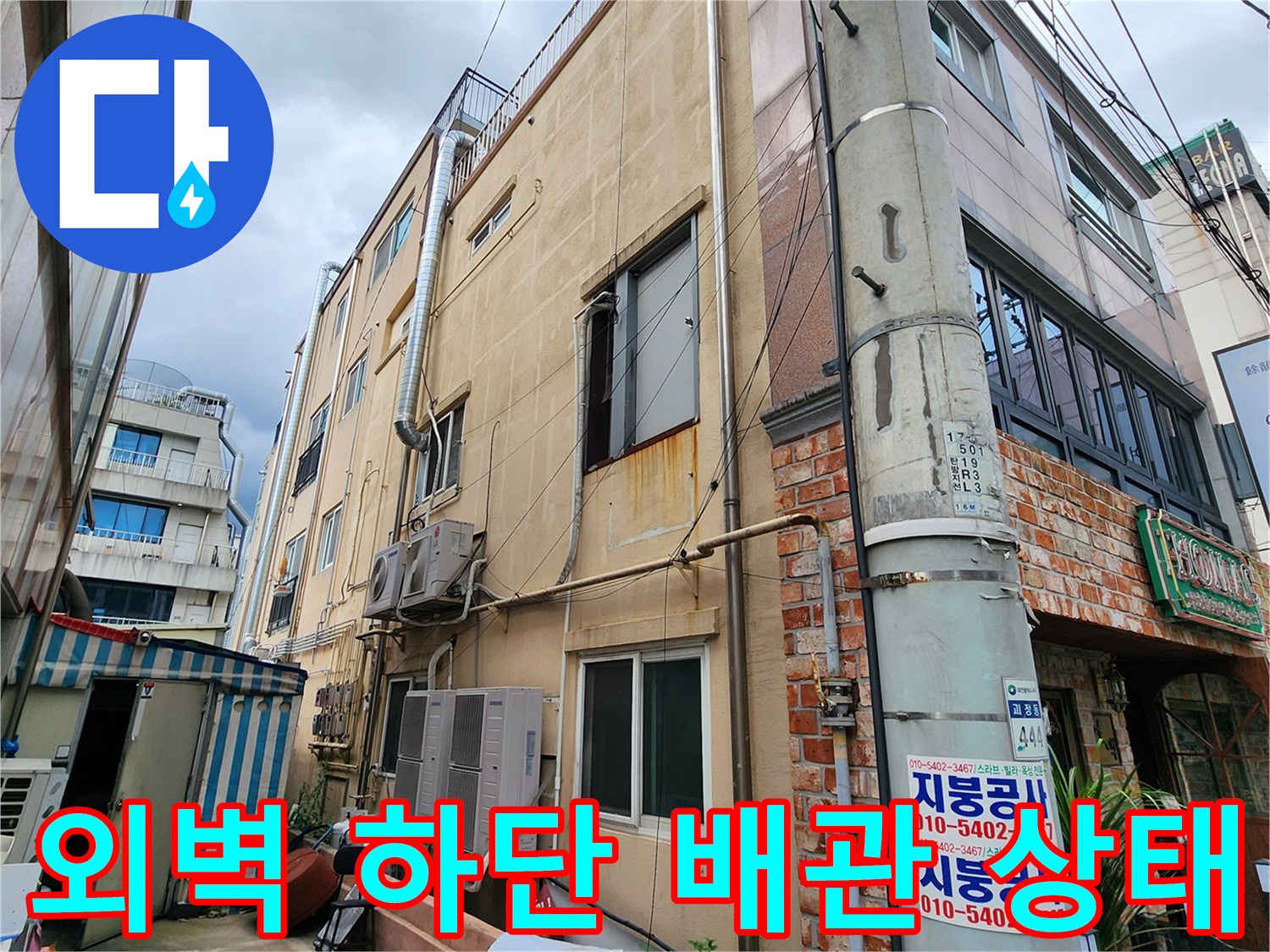 건물 외벽의 노출된 배관과 벽면 마감 부위 상세 촬영