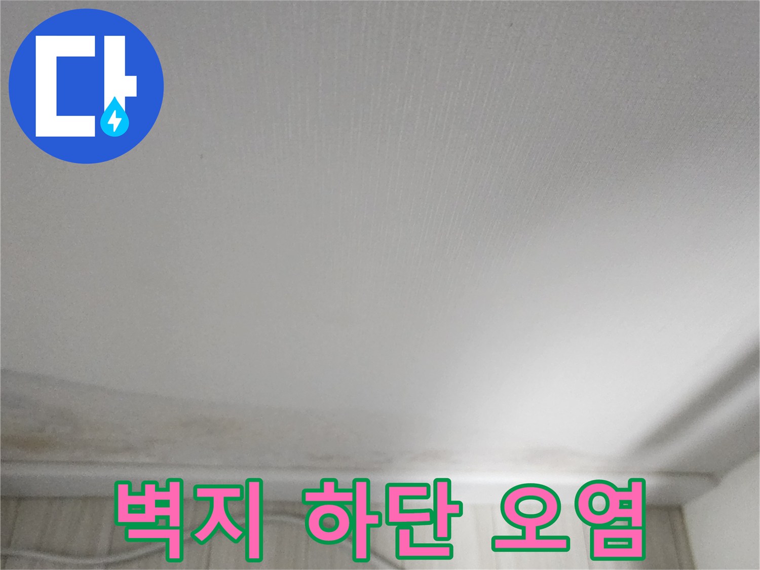 실내 벽면 하단에 발생한 누런색의 물자국과 변색된 벽지 모습