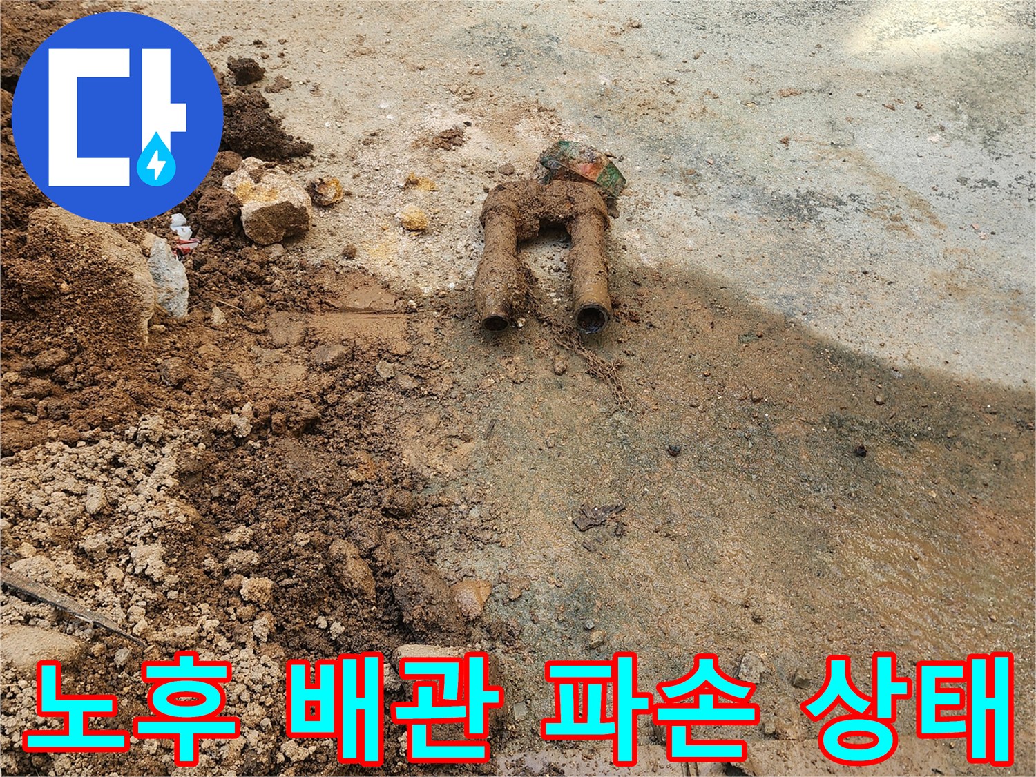 흙과 콘크리트 사이로 드러난 부식된 금속 배관