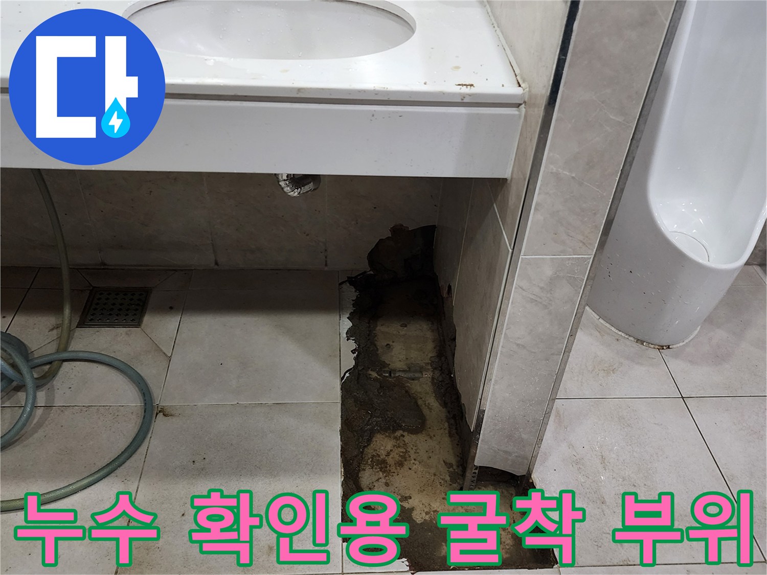 세면대 아래 바닥 타일을 제거하여 내부 배관 상태를 점검하는 모습입니다.