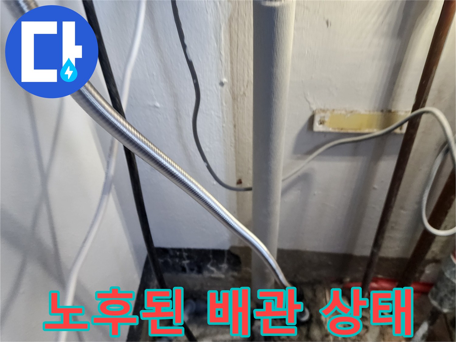 바닥 근처에 위치한 수직 배관과 연결 부위의 모습입니다.