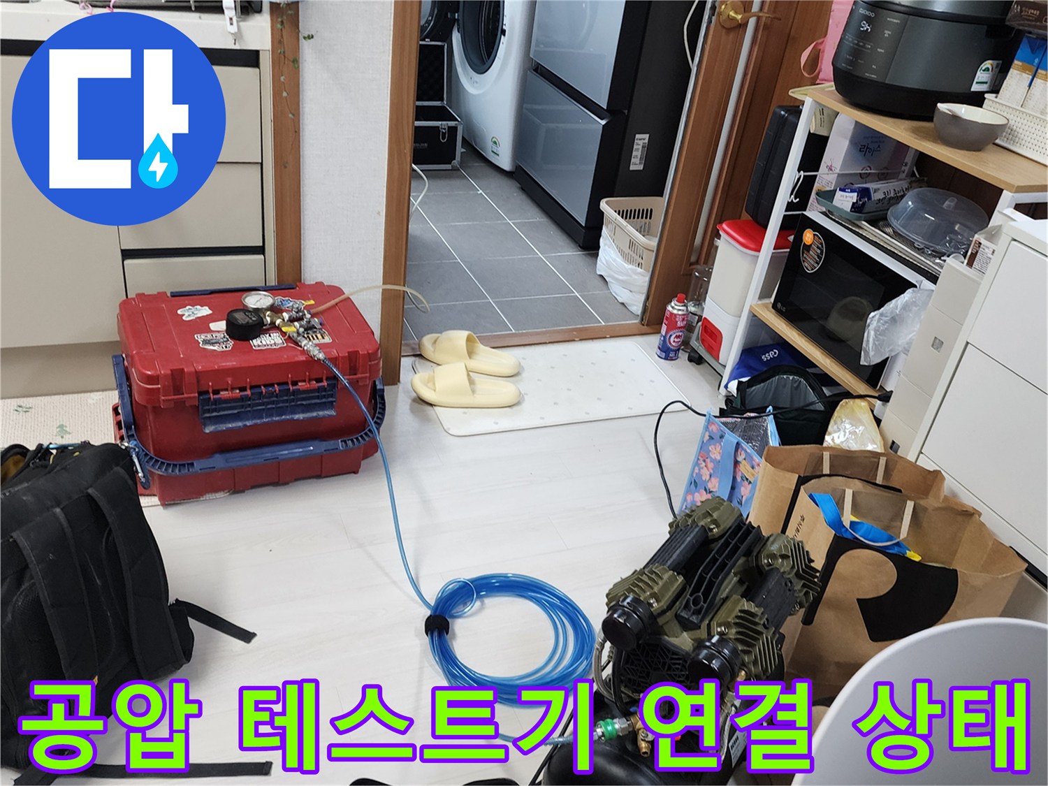 배관 누수를 찾기 위해 공압 장치와 호스를 배관에 연결한 모습입니다.