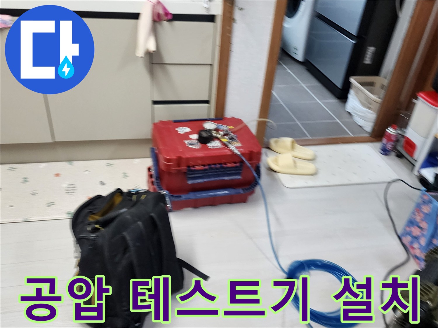 주방 바닥의 붉은색 공구상자와 파란색 에어 호스 연결 상태