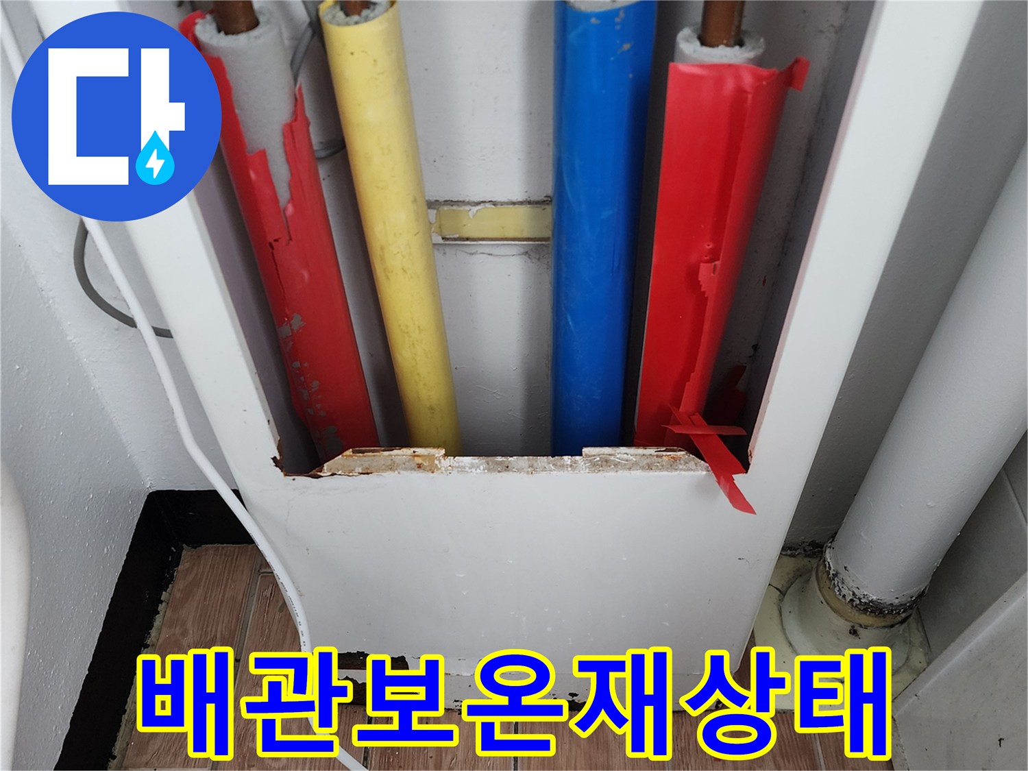 주방 싱크대 아래 여러 색상의 보온재로 감긴 배관들 모습