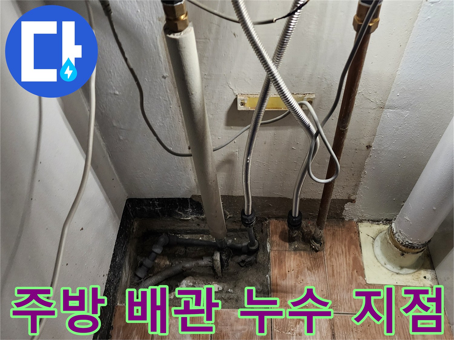 주방 하부 배관의 연결 부위와 노후된 배수 라인 상태를 보여주는 사진입니다.
