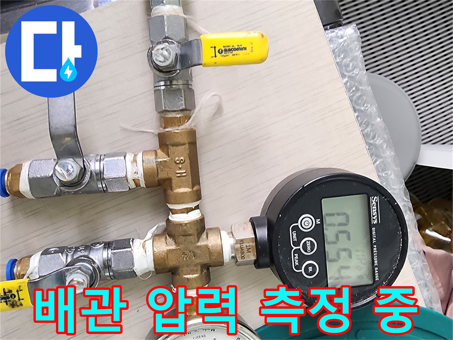 금속 밸브와 디지털 게이지가 연결된 배관 시스템의 근접 촬영 사진입니다.