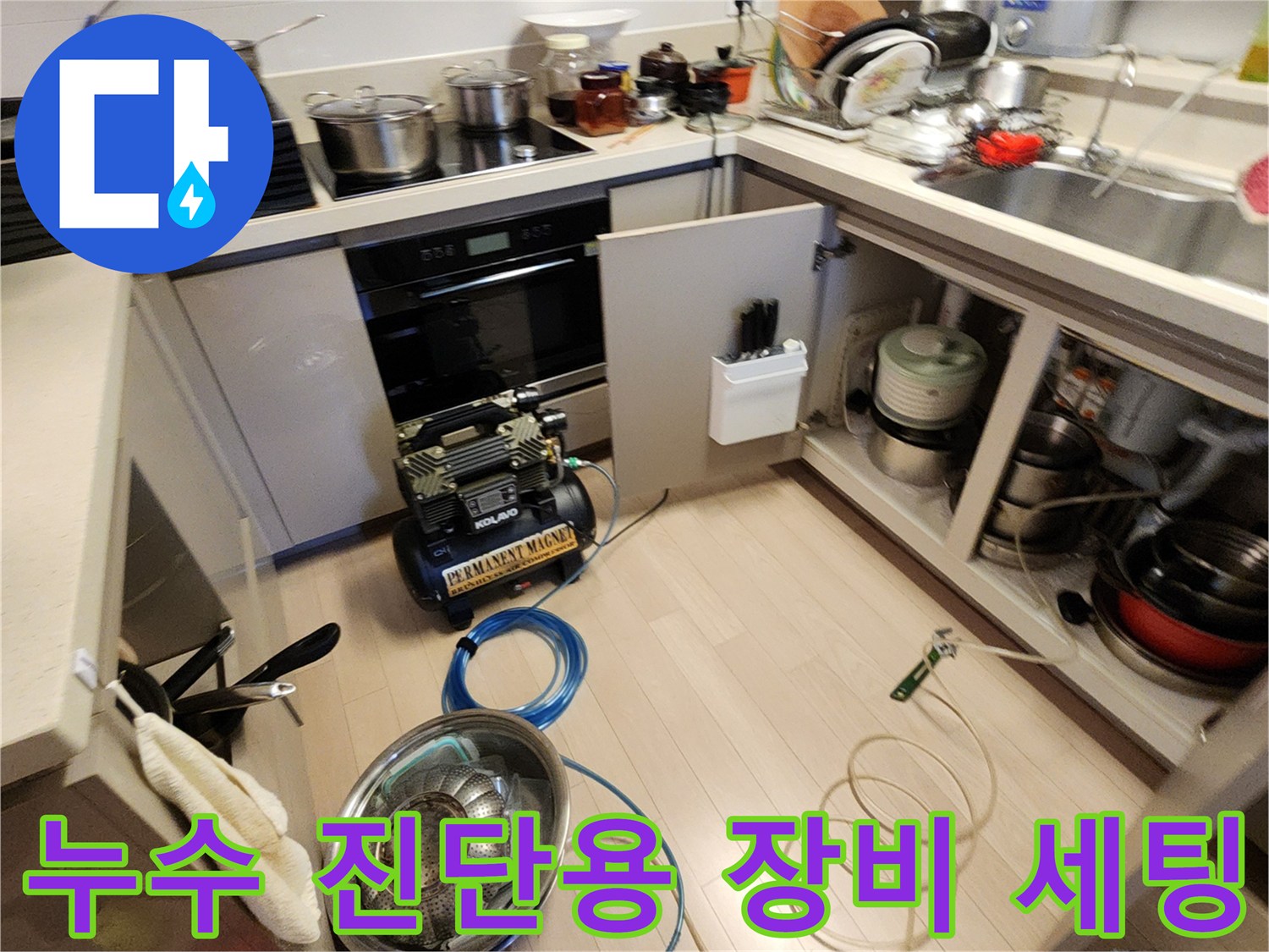 주방 하부장 앞쪽으로 연결된 누수 탐지용 공압 장비와 호스 릴
