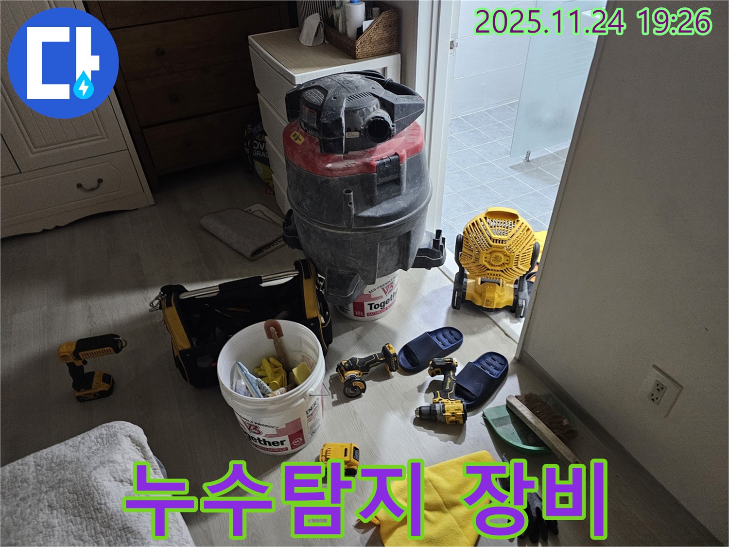 누수 탐지를 위한 다양한 장비 - 습식 청소기, 드릴, 공구통 등이 준비되어 있습니다.