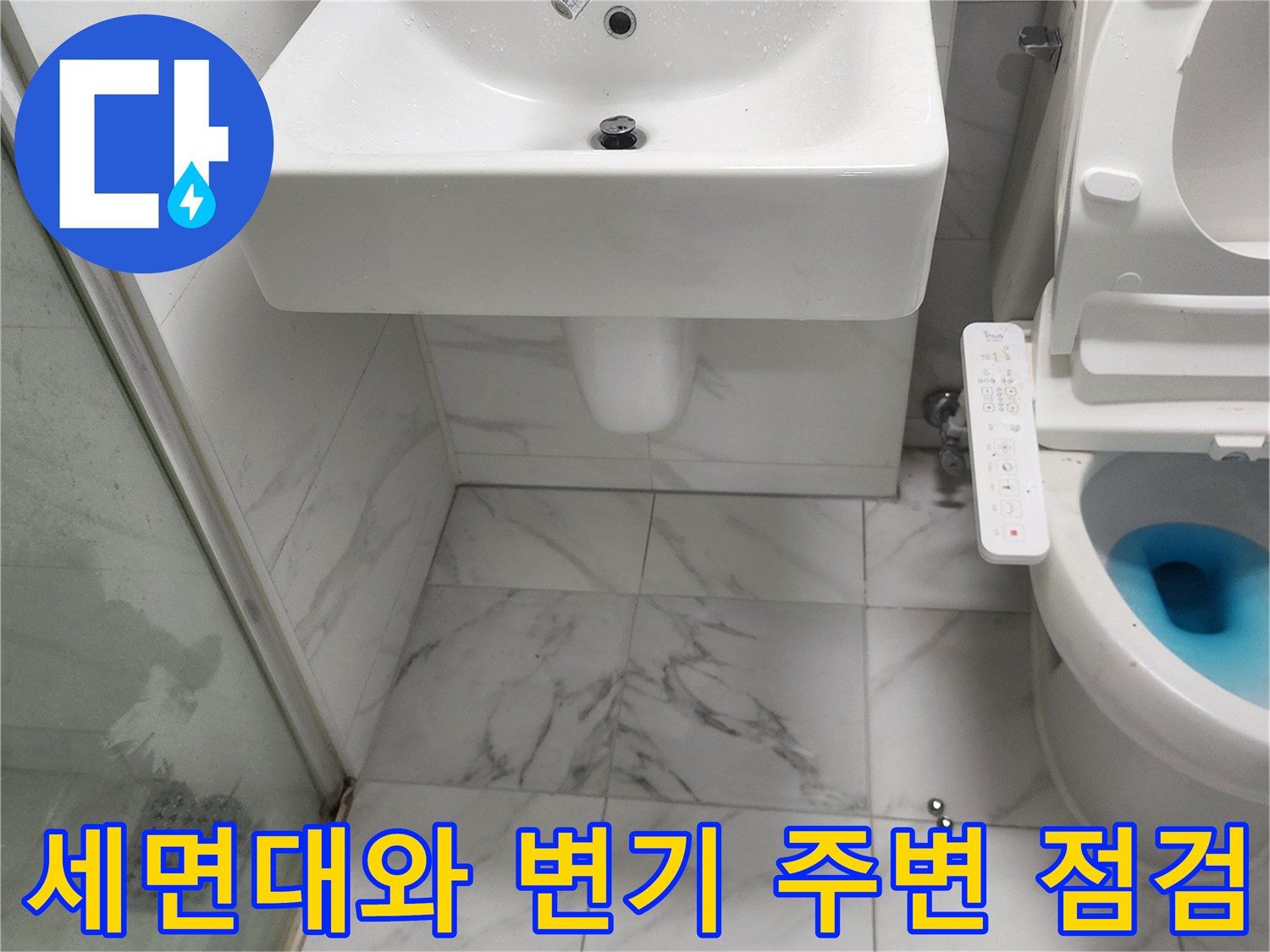 화장실 세면대 하부와 양변기 근처를 촬영한 사진입니다.