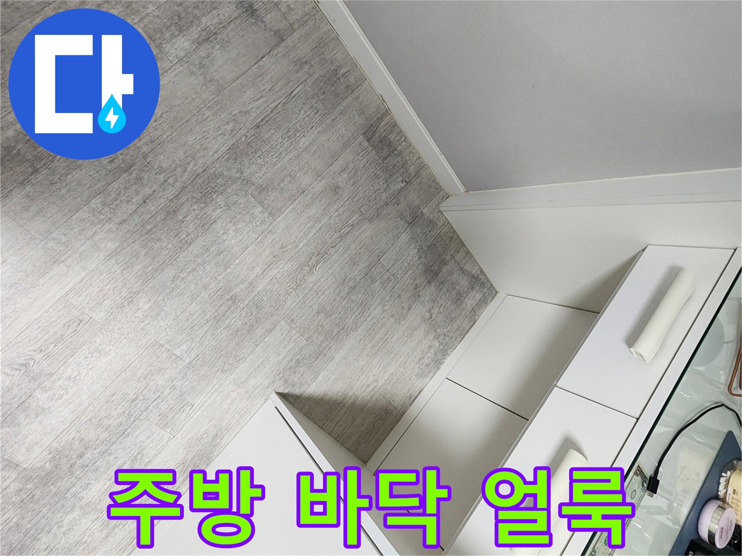 싱크대 하단부 마루의 어두운 변색 부위 상세 사진