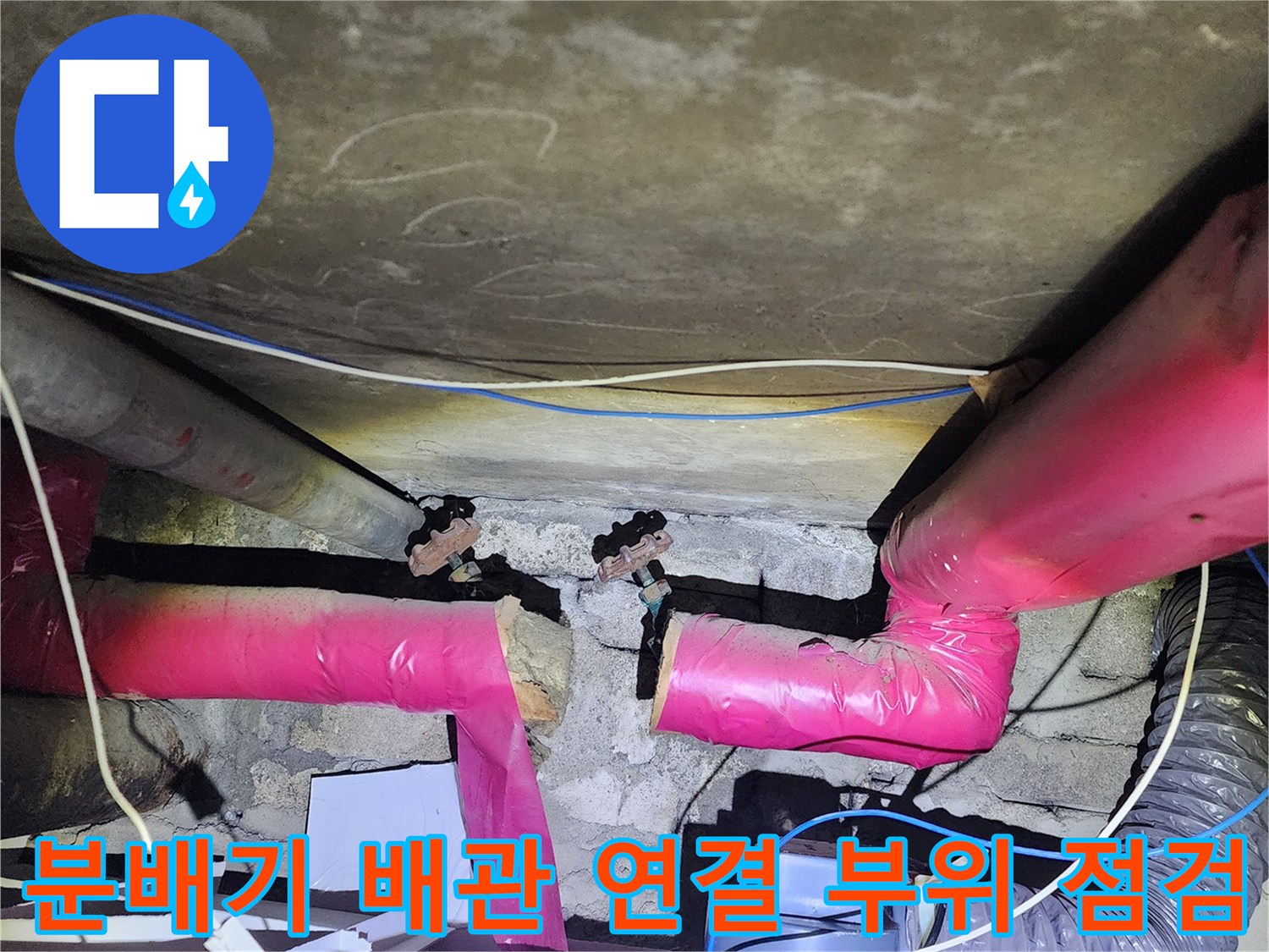 아파트 하부 천장 배관의 분배기 연결 부위와 보온재 상태를 확인하는 모습입니다.