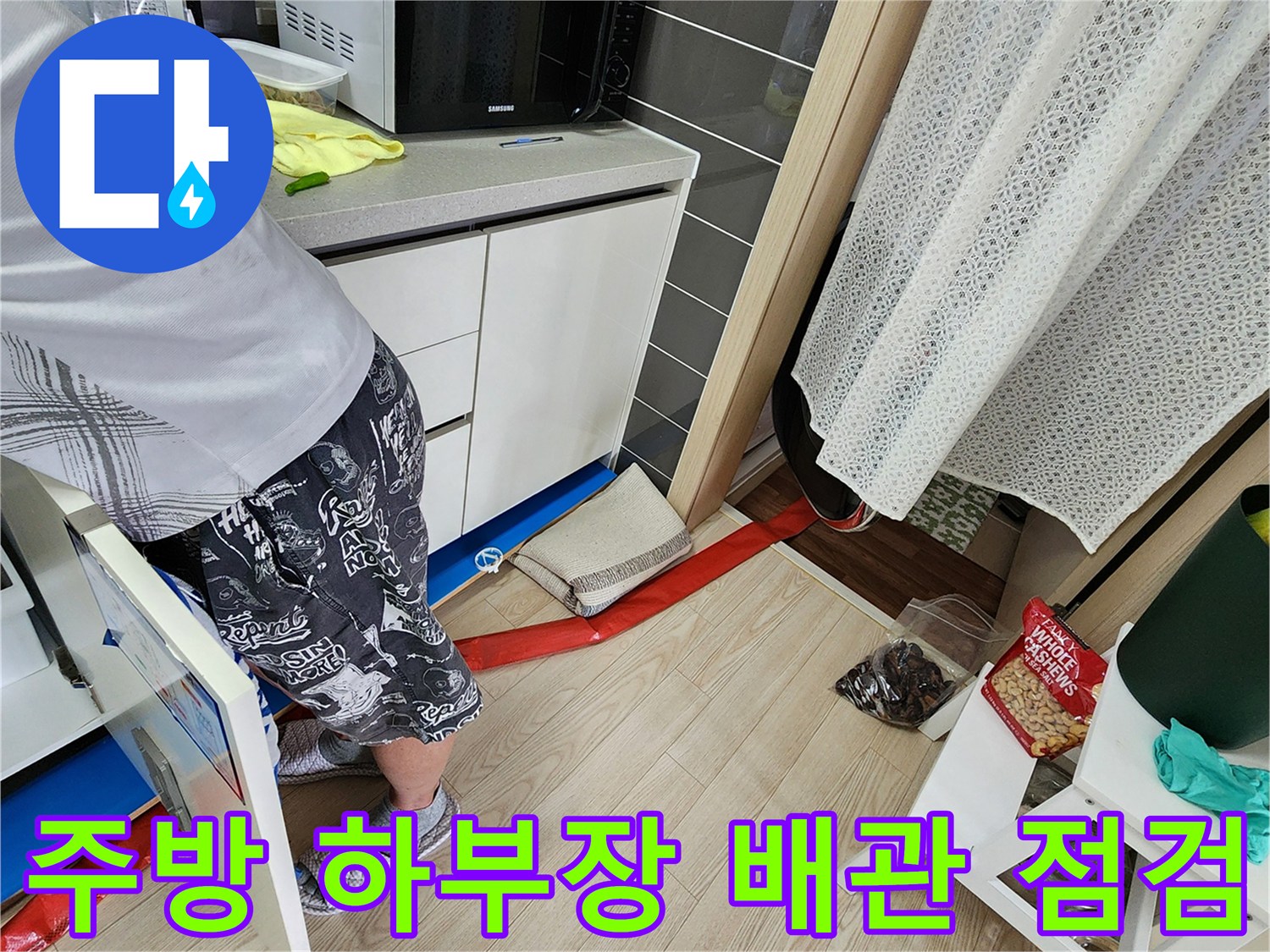 싱크대 하부장 아래쪽 바닥에 설치된 붉은색 차단재와 주변 환경
