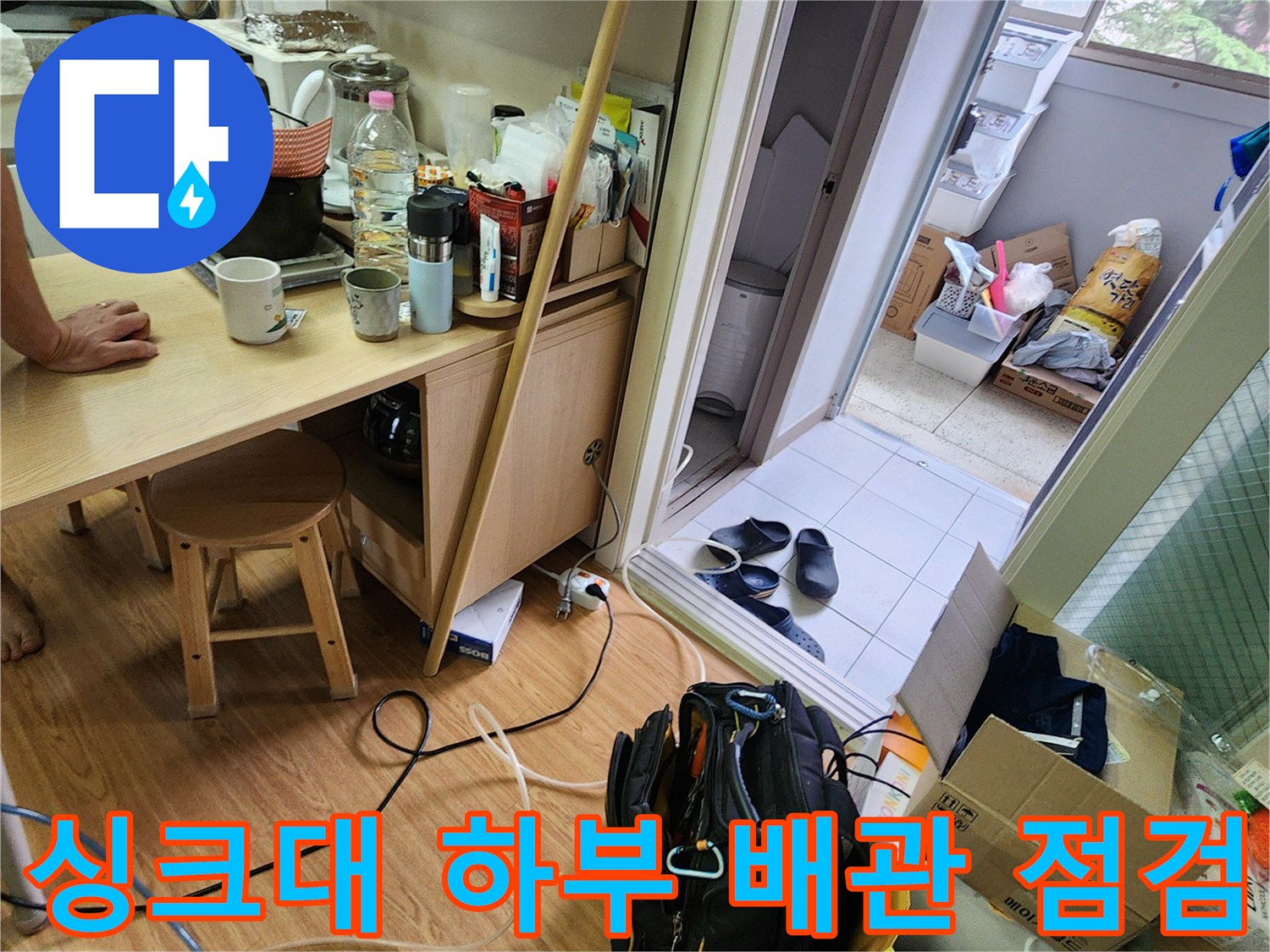 주방 가구 아래쪽 바닥에 배치된 누수 탐지용 장비 가방
