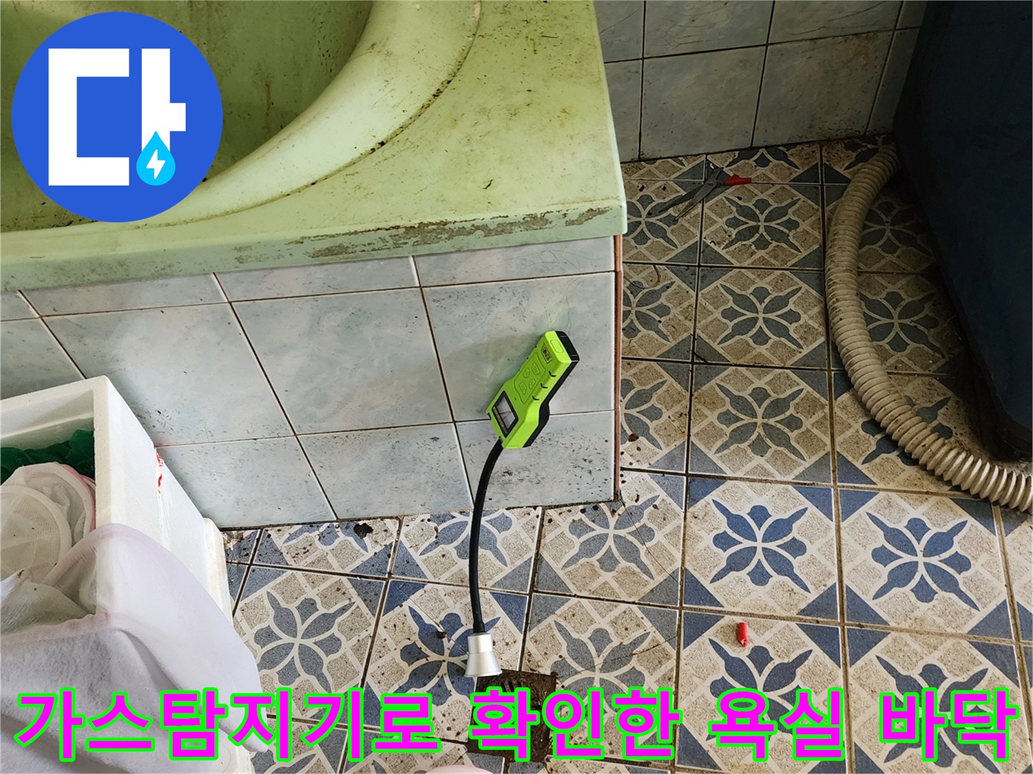 가스 탐지기를 사용하여-욕실 타일 바닥의 누수 지점을 정밀하게 점검하는 모습