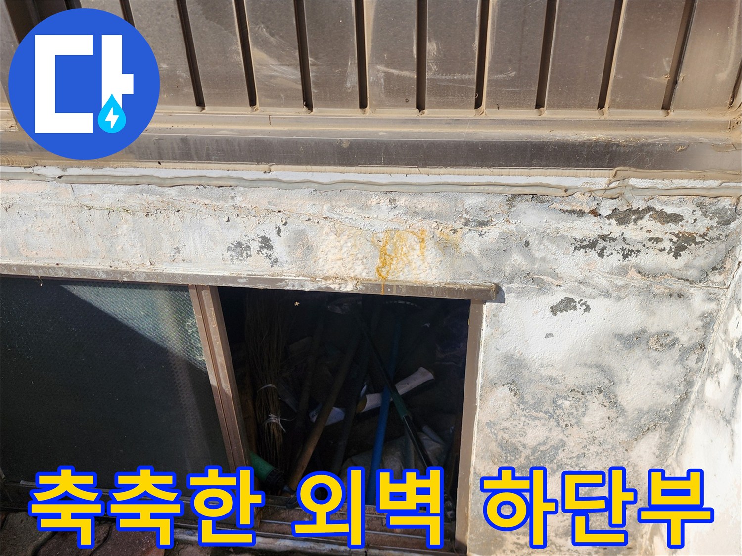 습기로 인해 변색된 건물 외벽의 하단 부분 사진