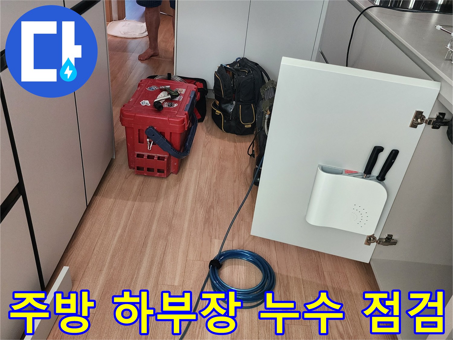 싱크대 밑 배관 연결부를 확인하기 위해 열어둔 하부장 내부
