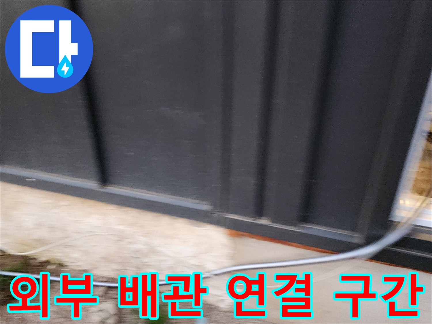 건물 하단 외벽에 설치된 금속 재질의 외부 배관
