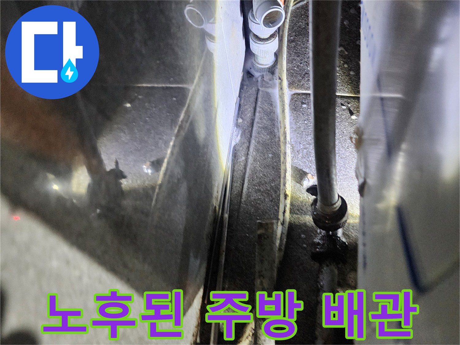 물기가 맺힌 금속 배관과 흰색 배관 부속의 근접 촬영
